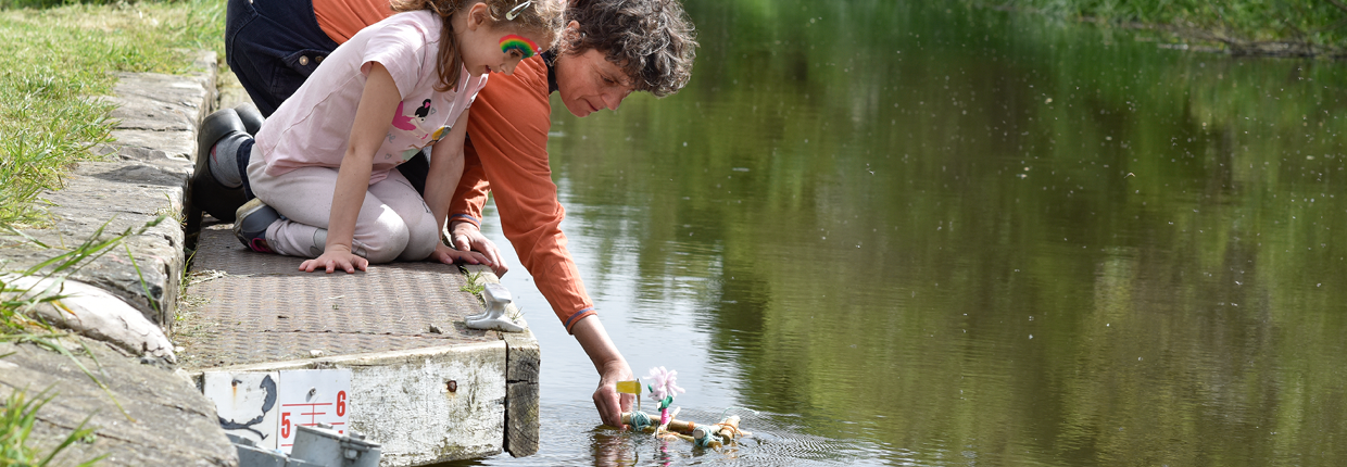 Sarah Kenchington helps a young artist float a raft during Edinburgh Art Festival's Canal Connections event. Photo: Julie Howden.