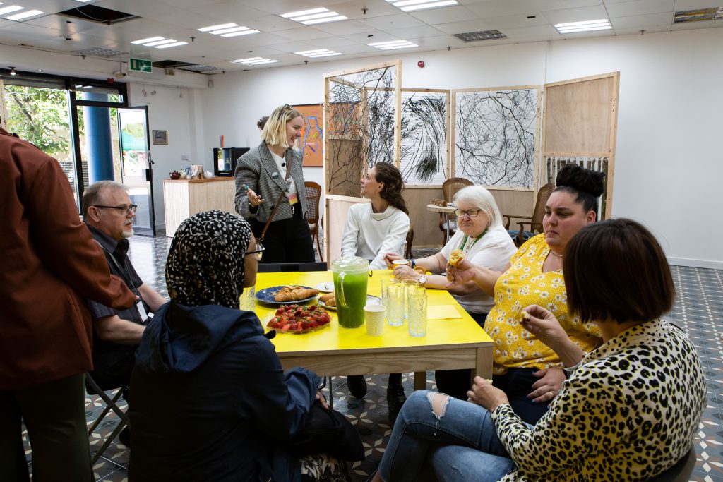 Interior of Community Wellbeing Space with group members around table.